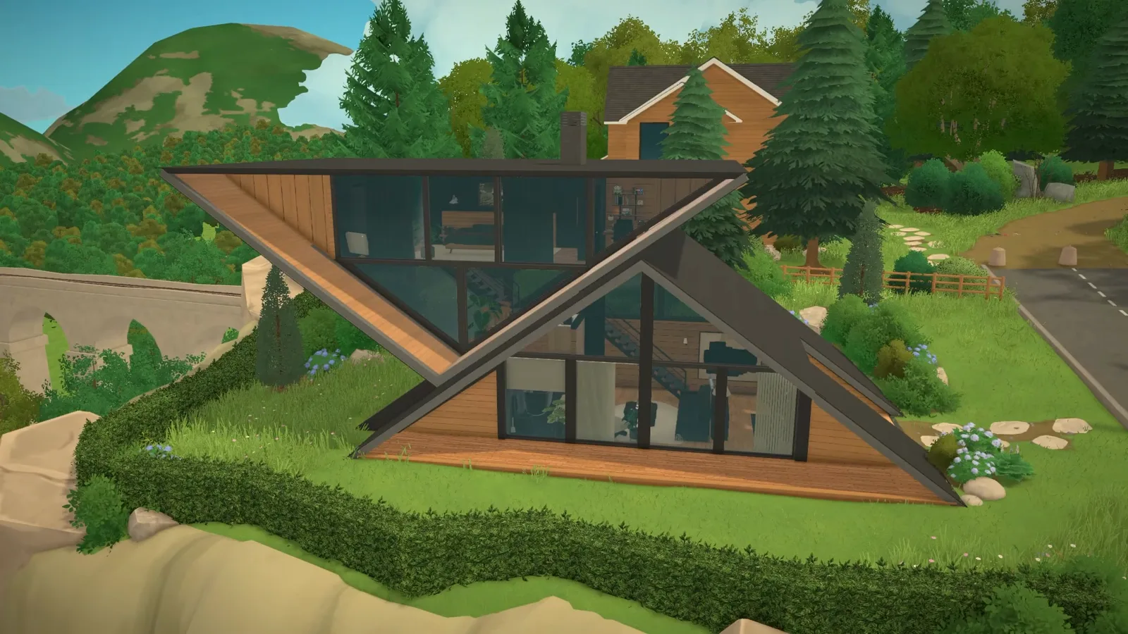 A finished black A-frame house in Paralives with a reversed V-shaped wing, timber-lined balconies and full-height glazing, photographed from the hedged hillside garden it was built into. A finished black A-frame house in Paralives with a reversed V-shaped wing, timber-lined balconies and full-height glazing, photographed from the hedged hillside garden it was built into.