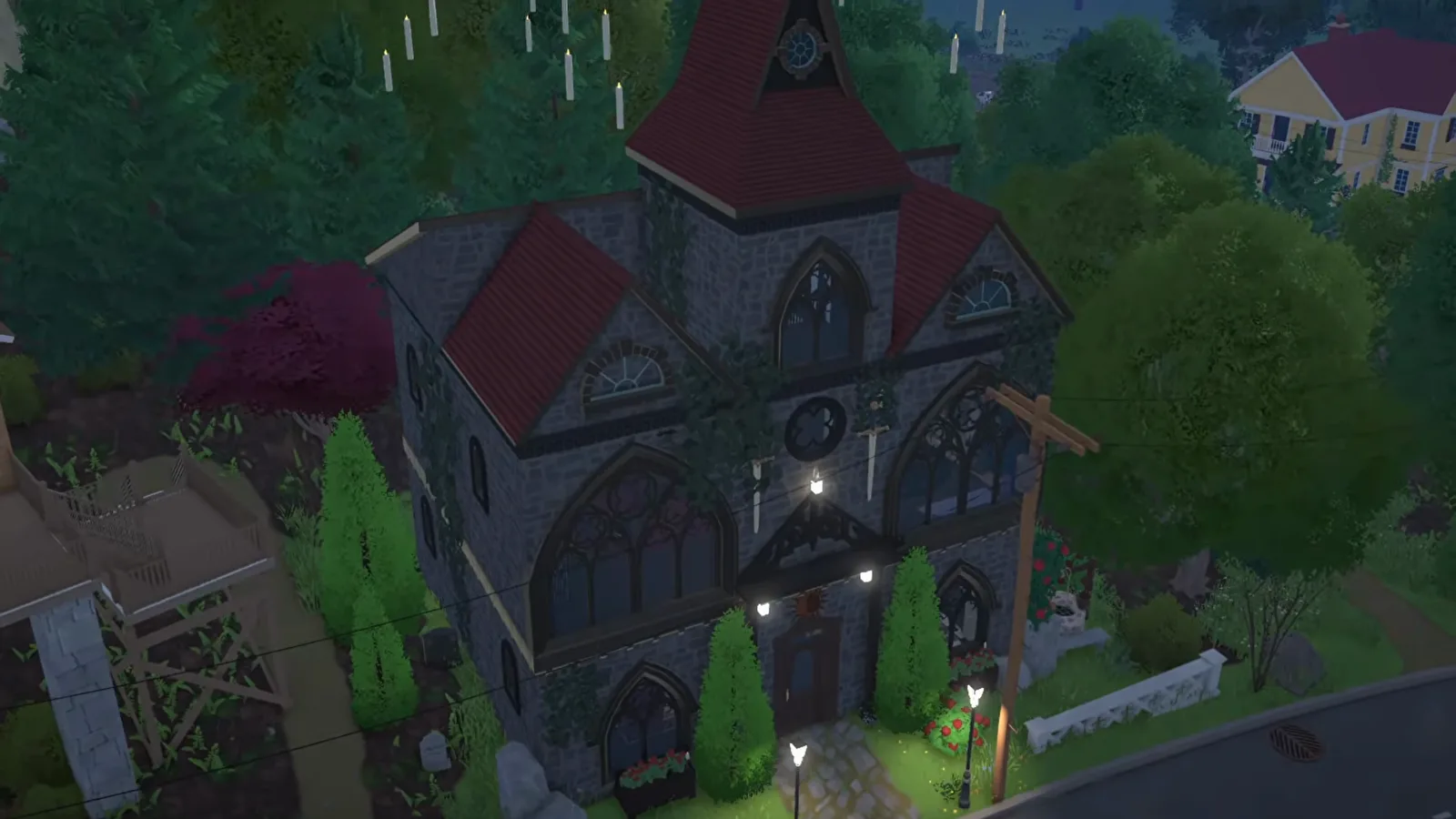 The finished Paralives gothic church conversion at night with warm light glowing through its pointed-arch windows above the front path The finished Paralives gothic church conversion at night with warm light glowing through its pointed-arch windows above the front path