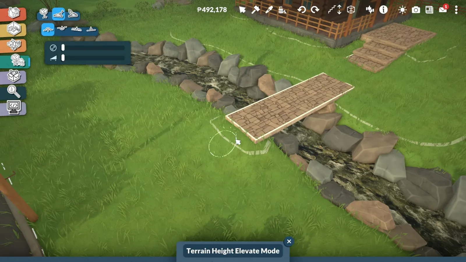 Terrain Height Elevate Mode raising the banks beneath a cobblestone floor platform bridging a rocky Paralives river.