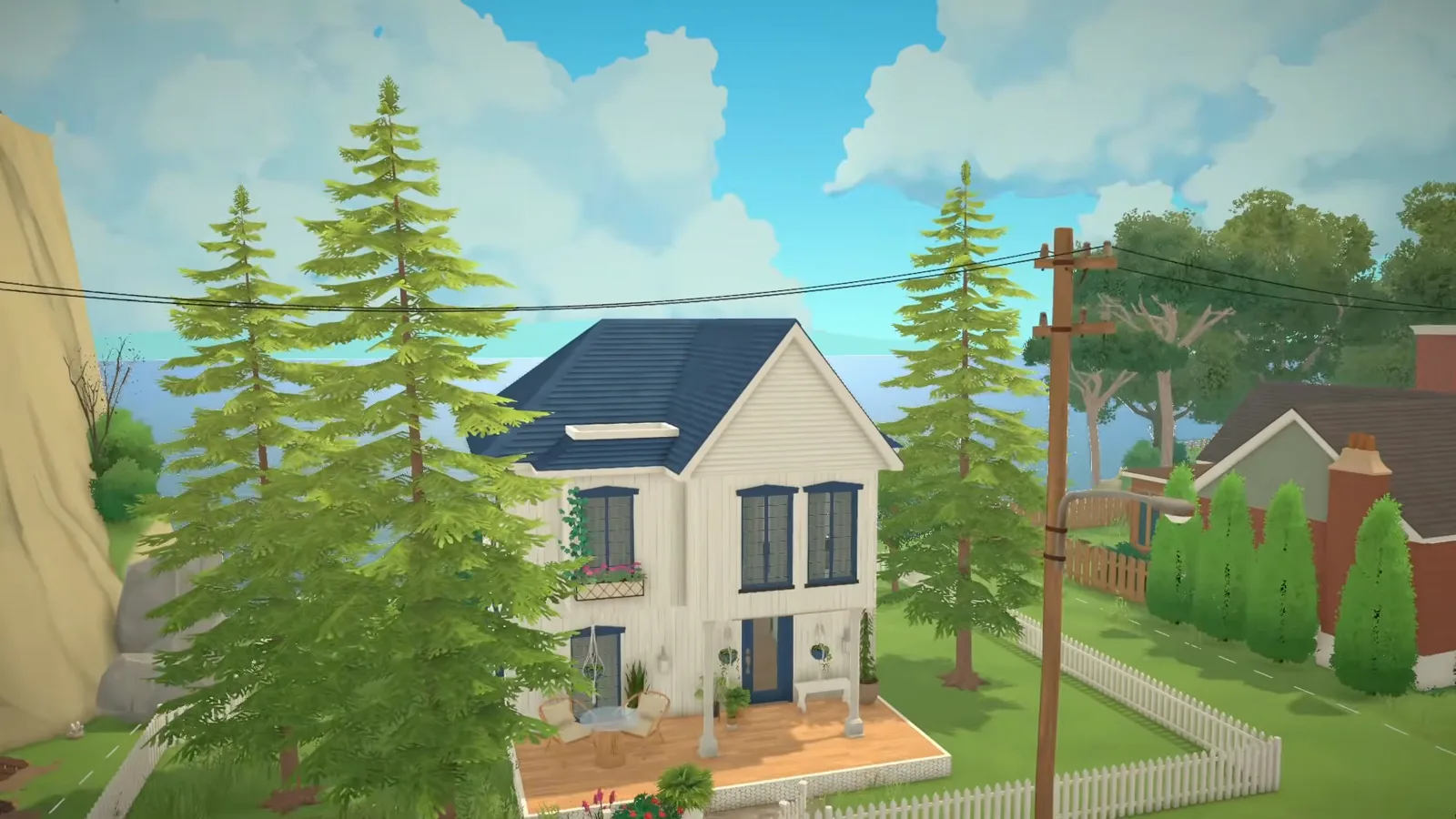 Finished Paralives Scandinavian coastal home: white two-storey house with navy gabled roof, navy-framed windows, flower box, porch with cafe table and a white picket fence by the sea